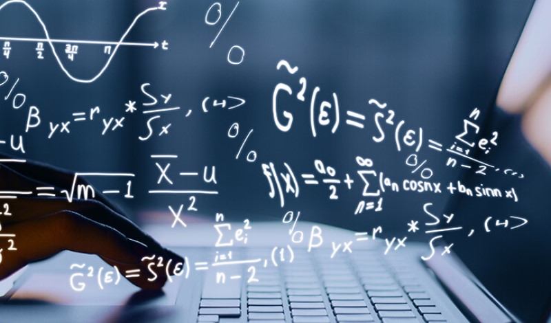 Computational mathematics formulas superimposed over fingers typing on a laptop keyboard.