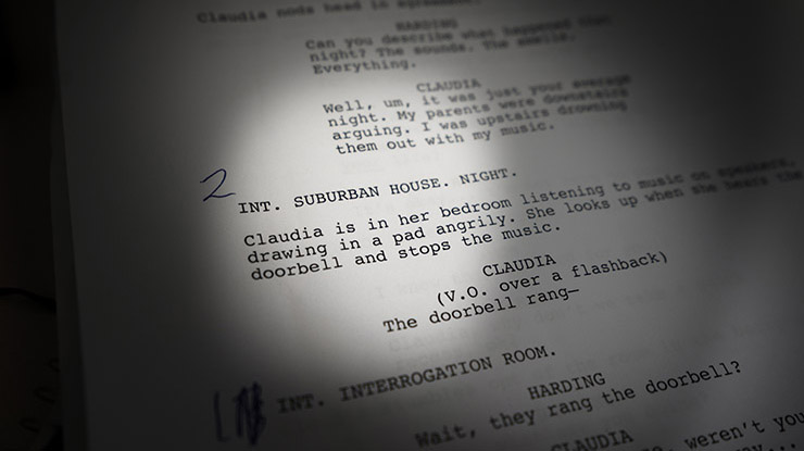 Close-up of an example of a movie script, the kind a film studies major would write. A small spotlight illuminates the page.