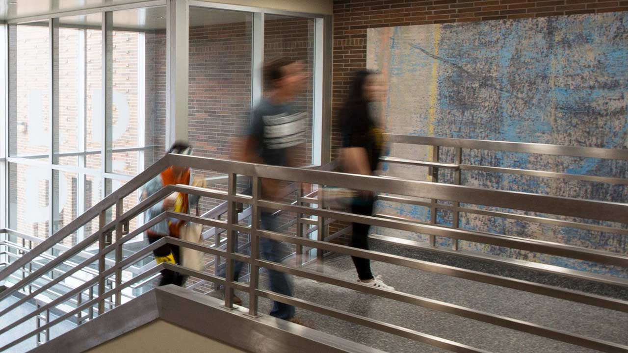 Students pursuing a human resource management degree walk up a metal staircase in one of MSU’s campus buildings.