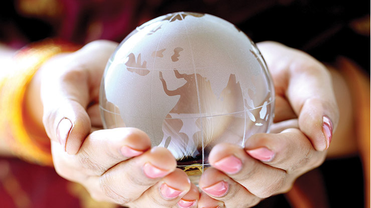 Close-up of two hands cradling a small glass globe, representing how philosophy majors examine the world.