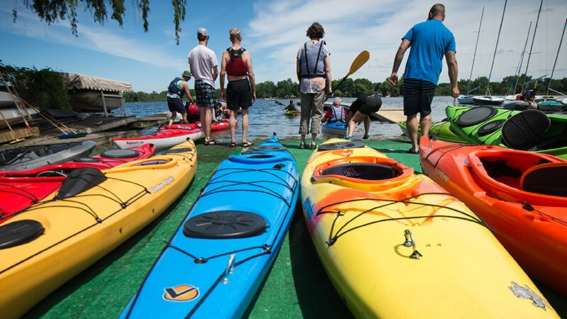 Michigan State students setting off on kayaks at a local lake.