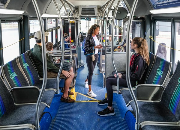 An interior photo of a campus bus showing student riders